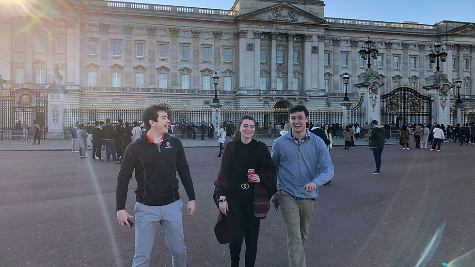 Jim Baker and two friends walk in front of Buckingham Palace.