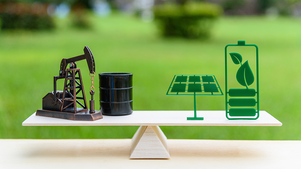 Fossil fuel vs renewable / future clean alternative energy concept : Petroleum pumpjack, crude oil drum barrel and solar panel, green battery with leaf on a simple wood balance scale in equal position