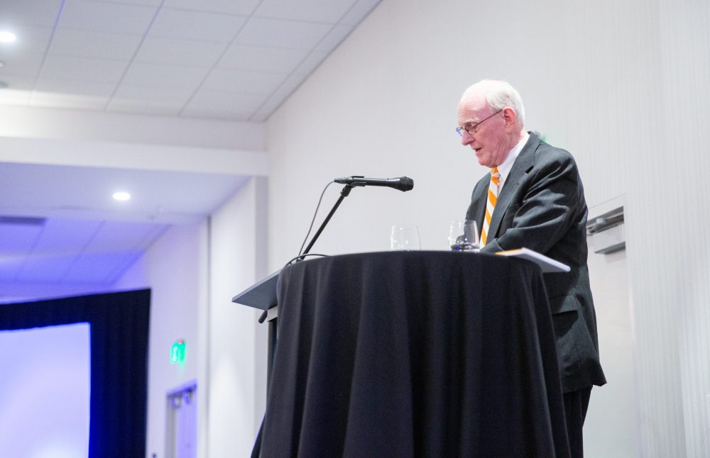 Mike Stone giving a speech onstage at a banquet