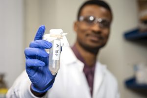 Christian Kemefa holding up a container of surfactants