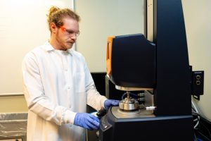 Zack Sparks setting up a machine in a lab