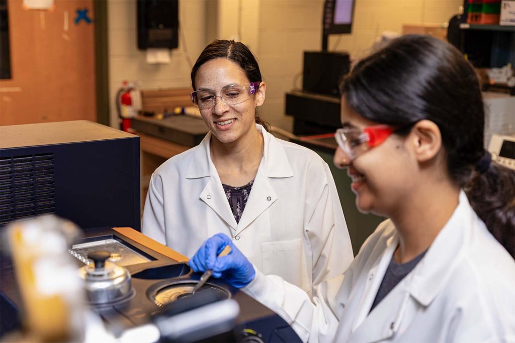 Ria Corder and Aditi Khatiwada working in a lab