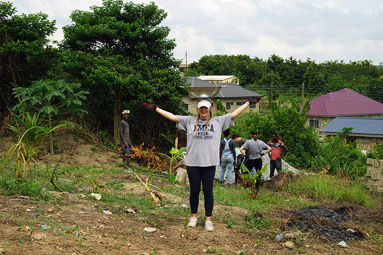 Kelsey Uselton poses in a field where the group was working.